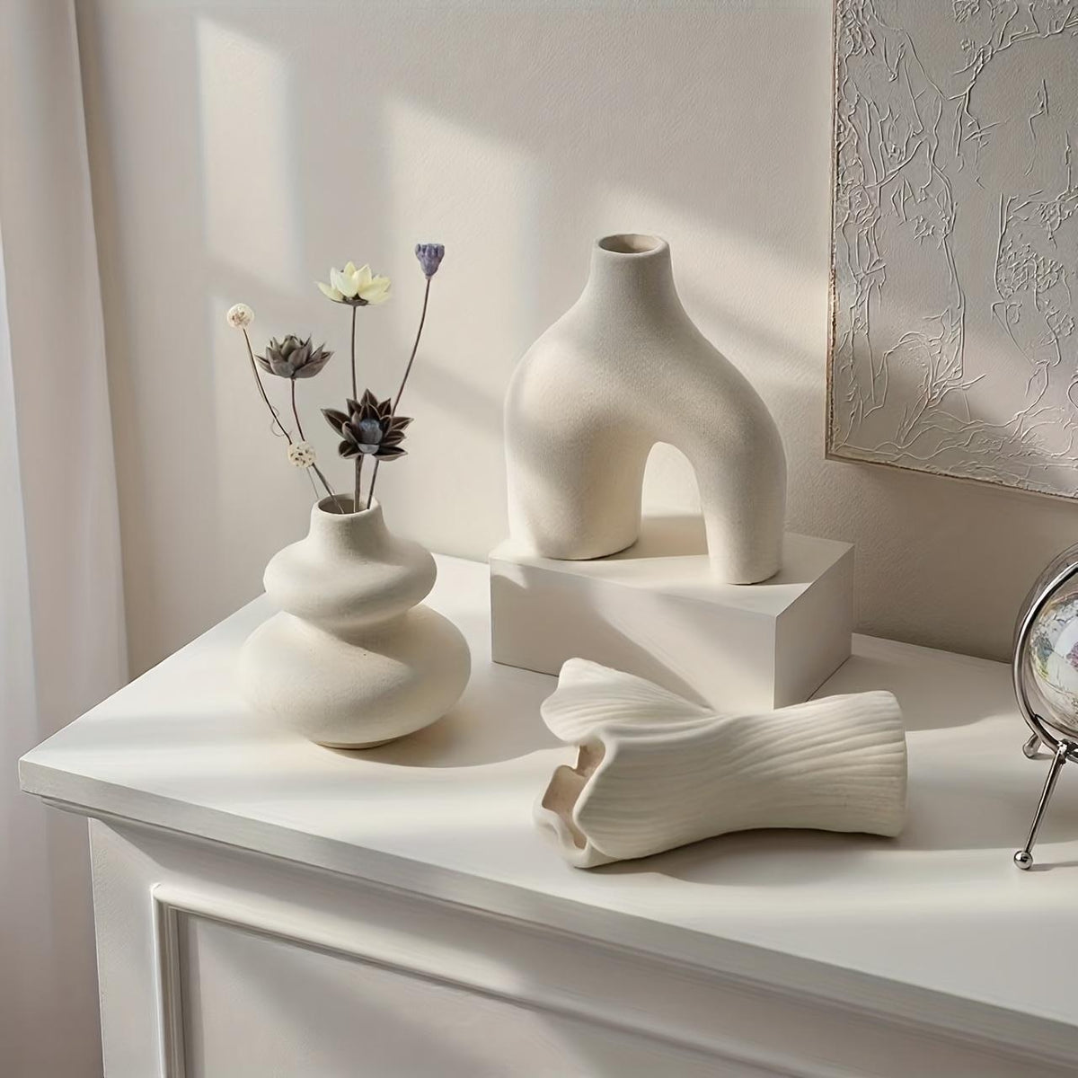 Matte white vase set of 3 on a white console in soft side light, the fan vase resting on its side