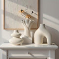 Sculptural matte white vase set of 3, arch, swirl and fan vases, on a white console against a textured wall