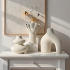 Sculptural matte white vase set of 3, arch, swirl and fan vases, on a white console against a textured wall