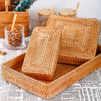 Woven rattan catchall trays stacked on a newsprint cloth beside glass jars of walnuts