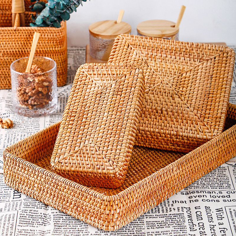 Woven rattan catchall trays stacked on a newsprint cloth beside glass jars of walnuts