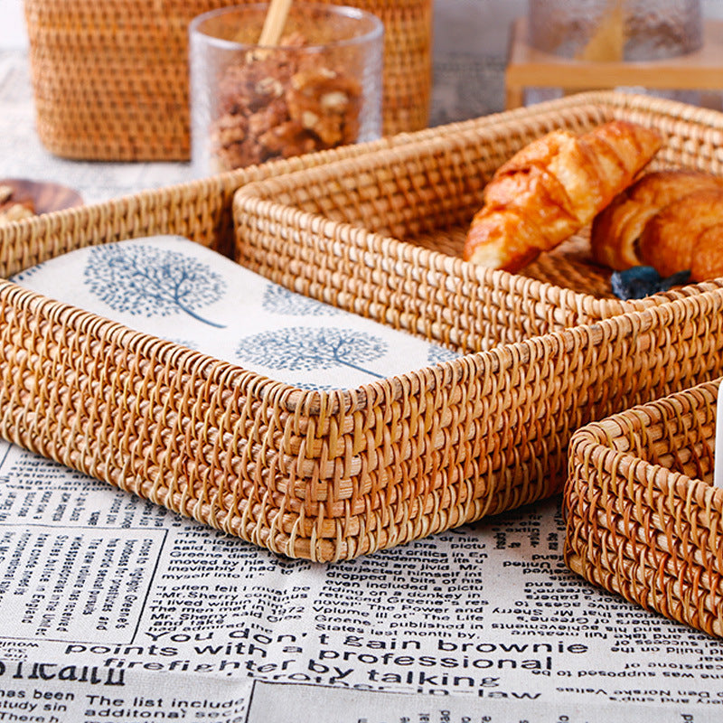 Large woven rattan tray holding croissants and a printed tea towel — detail of the wrapped rim