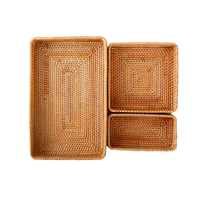 Shallow woven rattan trays in small, square medium and large sizes, top-down on a plain white background
