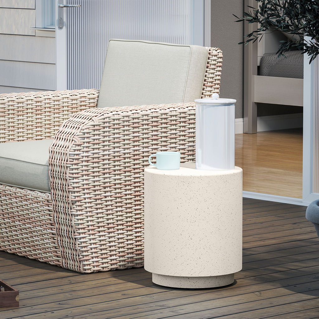 Speckled concrete-look drum side table on a wood deck beside a wicker lounge chair