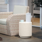 Speckled concrete-look drum side table on a wood deck beside a wicker lounge chair