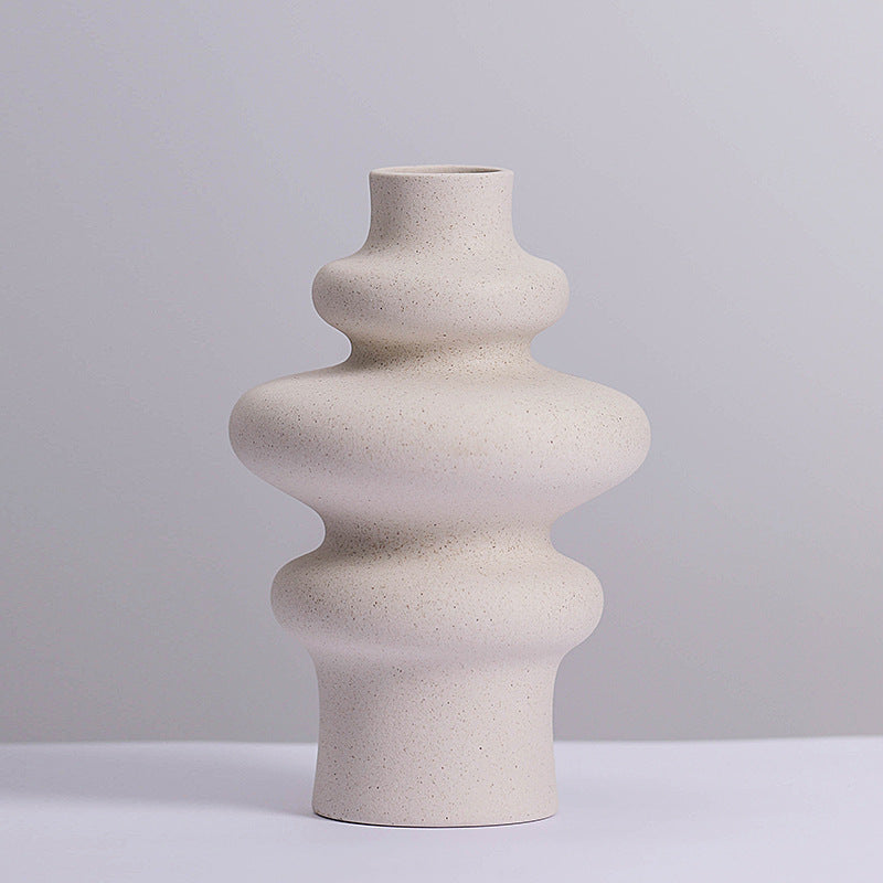 Three ring stacked ceramic vase in speckled matte cream against a soft grey backdrop