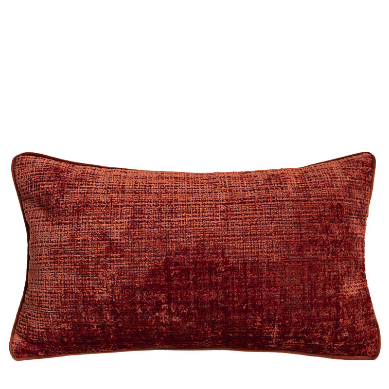 Textured chenille lumbar pillow cover in rust with matching piping on a plain white background