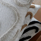 Tufted abstract line pillow covers in beige, camel and black, detail of the raised loop-pile lines