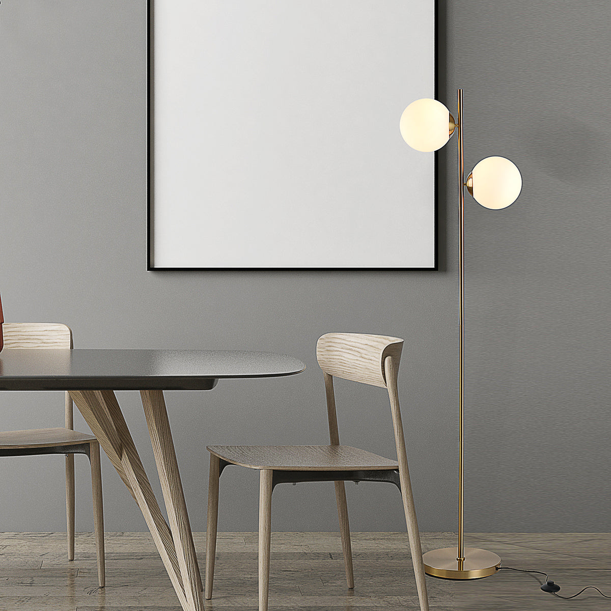 Gold twin globe floor lamp by a dining table and wood chairs against a gray wall