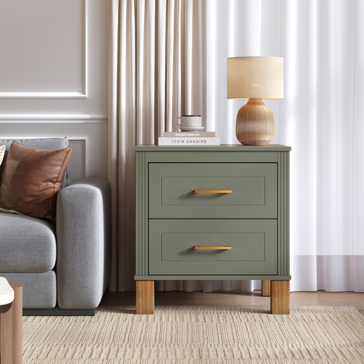 Olive green two-drawer nightstand beside a gray armchair under a linen-shade lamp