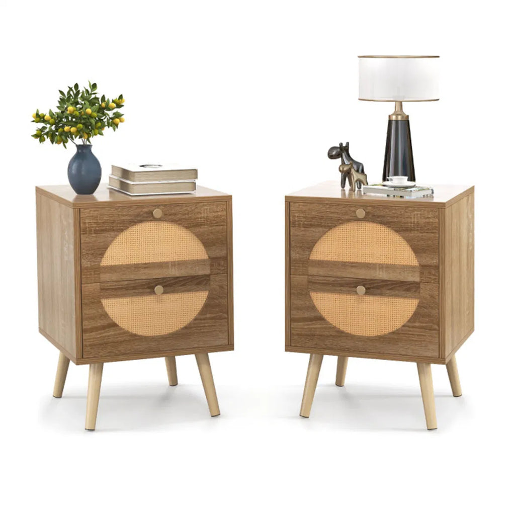 Two rattan nightstands styled with a lamp, books and a vase on a white background