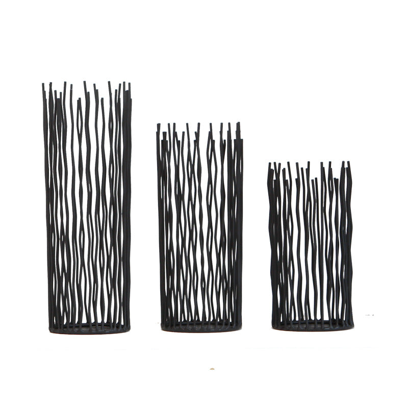 Black wavy iron rod pillar candle holders in small, medium and large on a plain white background