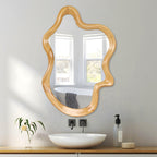 Wavy wood-finish wall mirror hung upright over a white vessel sink in a bright bathroom