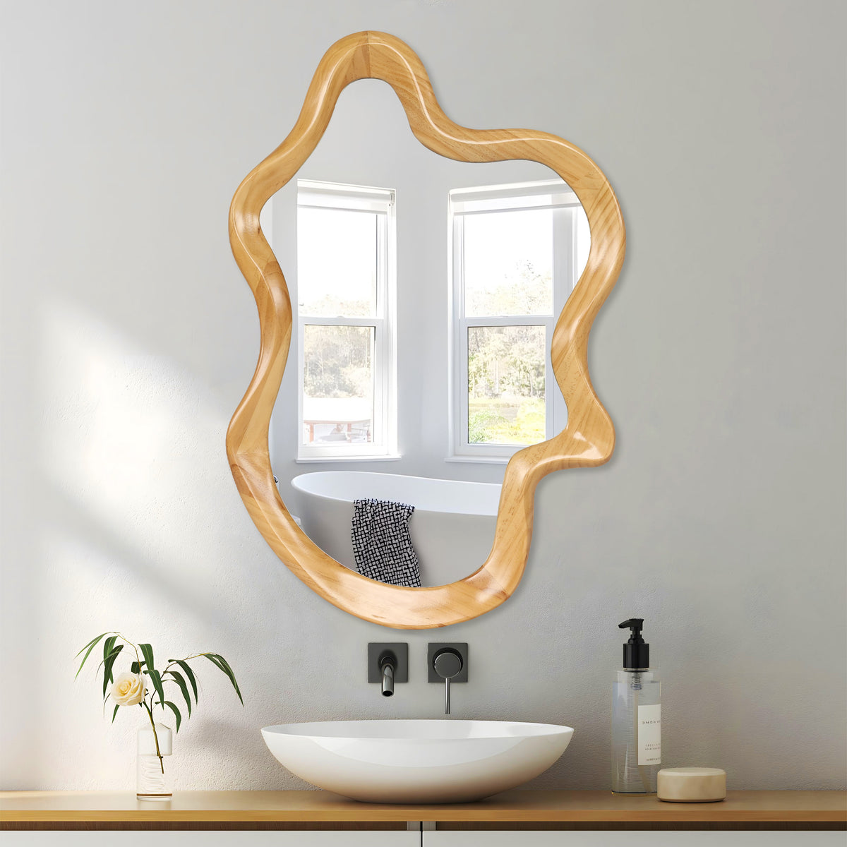Wavy wood-finish wall mirror hung upright over a white vessel sink in a bright bathroom