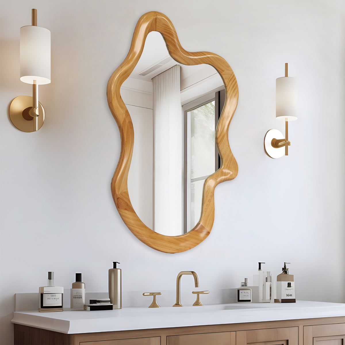 Irregular wavy mirror with wood-grain frame above a bathroom vanity between two wall sconces