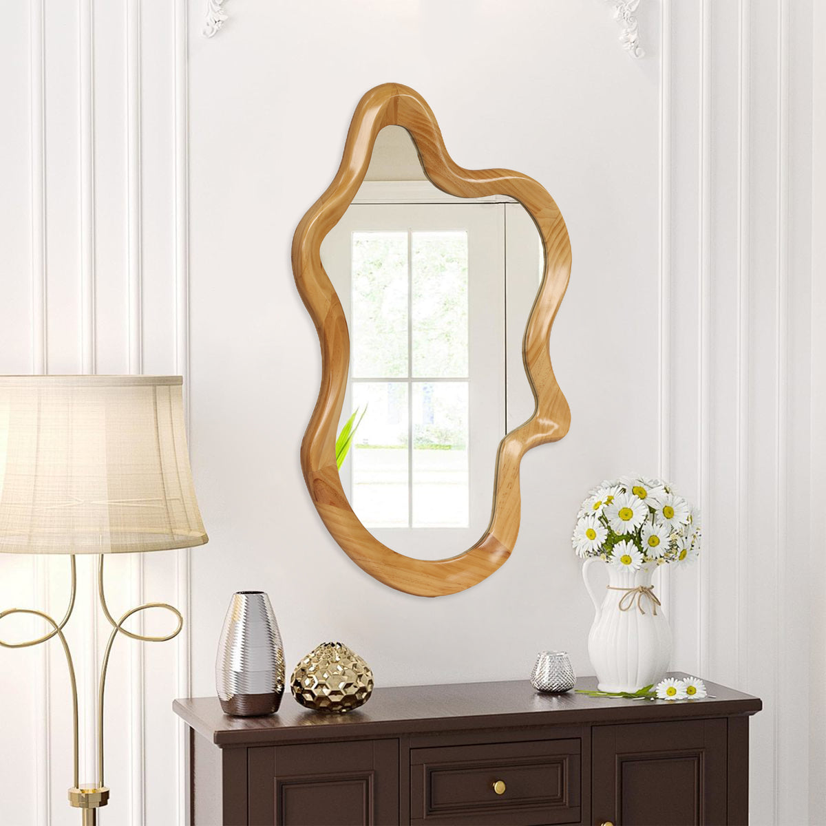 Wavy wood-finish wall mirror above a dark wood dresser with white flowers