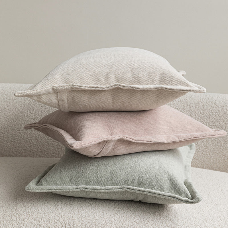 Wide flange-edge chenille pillow covers in oatmeal, dusty rose and sage stacked on a cream sofa