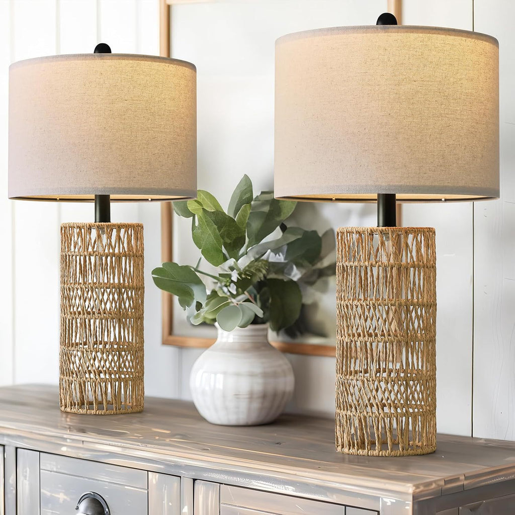 Two woven rattan table lamps on a whitewashed dresser with a green plant (each sold separately)