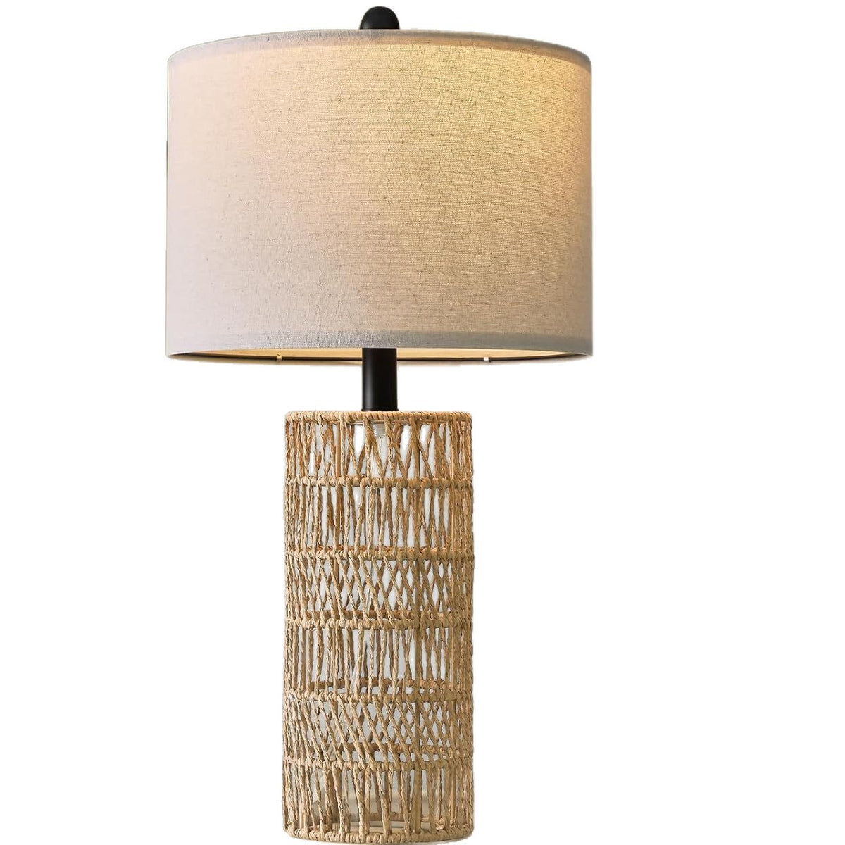 Woven rattan column table lamp with linen-look drum shade, lit, on a plain white background