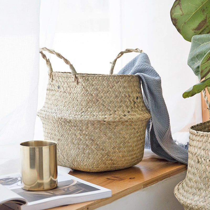 Seagrass belly basket with a grey throw over the rim — detail of the weave and handles
