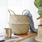 Seagrass belly basket with a grey throw over the rim — detail of the weave and handles