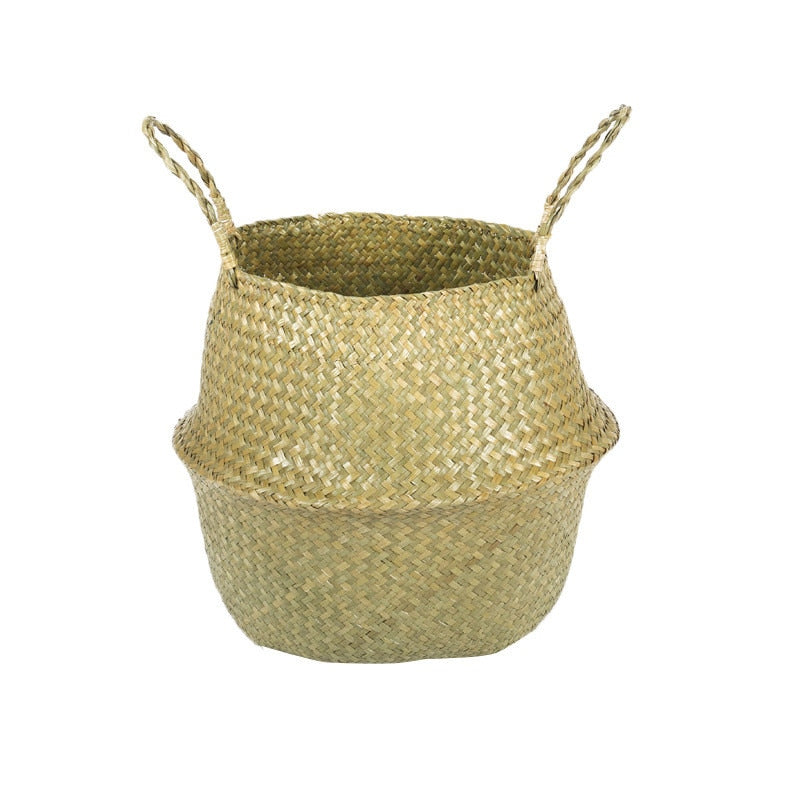 Natural woven seagrass belly basket with two twisted handles on a plain white background