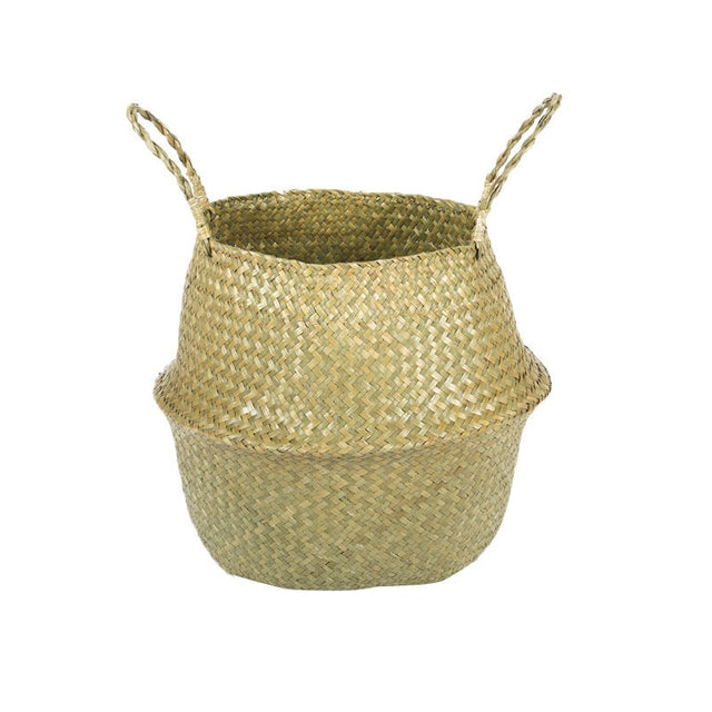 Natural woven seagrass belly basket with two twisted handles on a plain white background