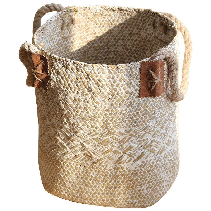 Whitewashed sand seagrass plant basket with rope handles on a plain white background